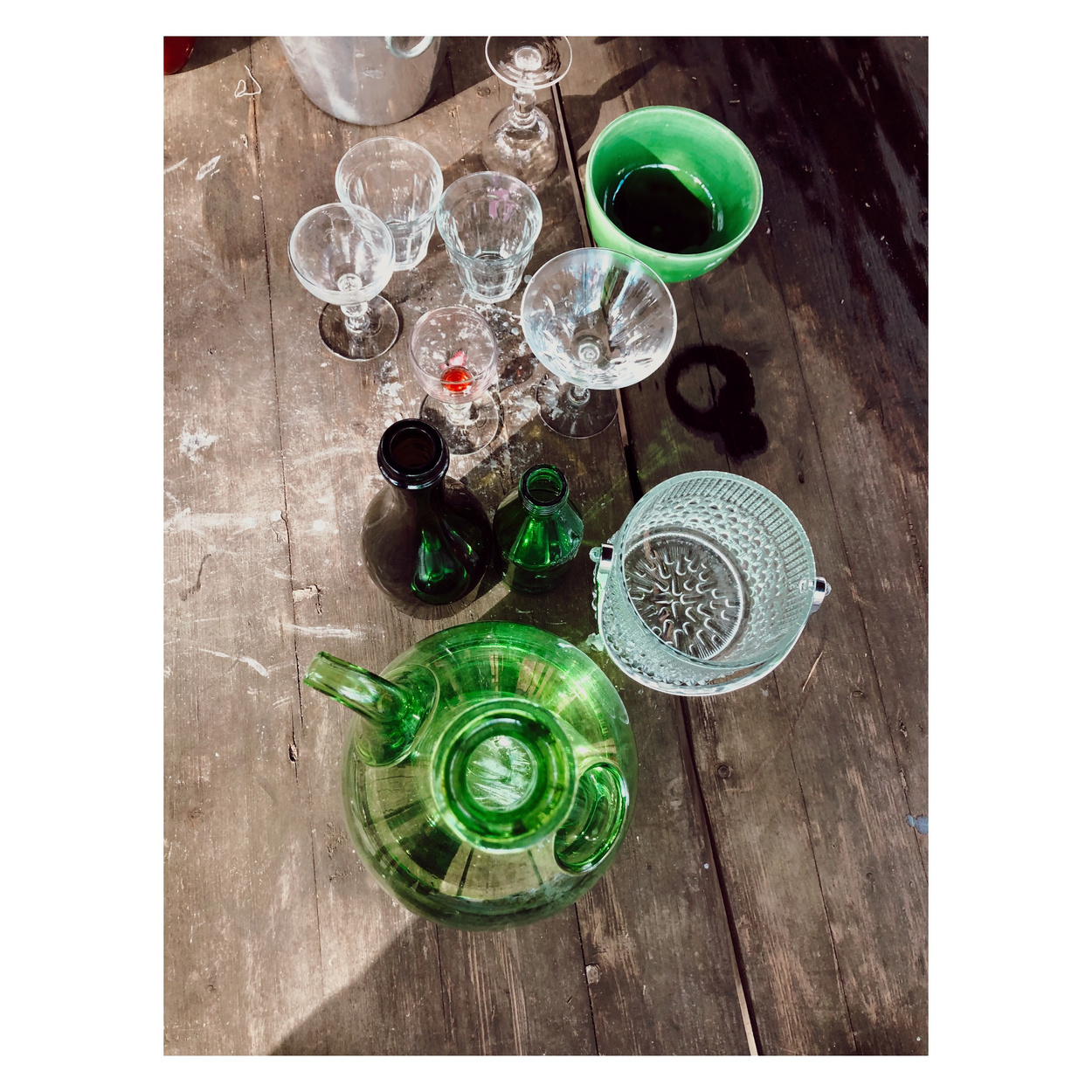 green glassware on a wooden table