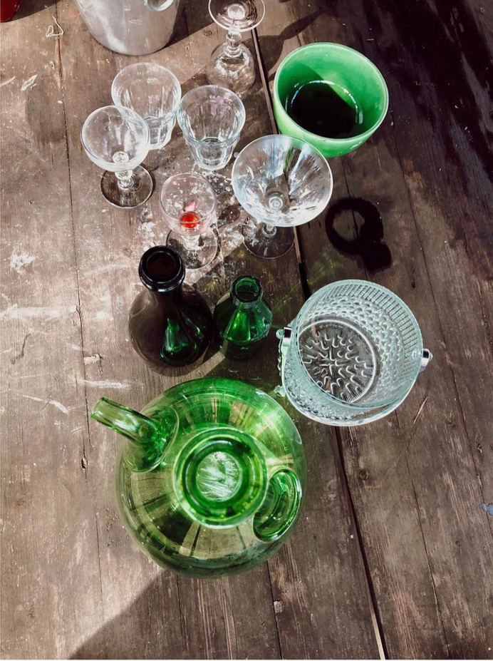 an assortment of green glassware on a wooden table