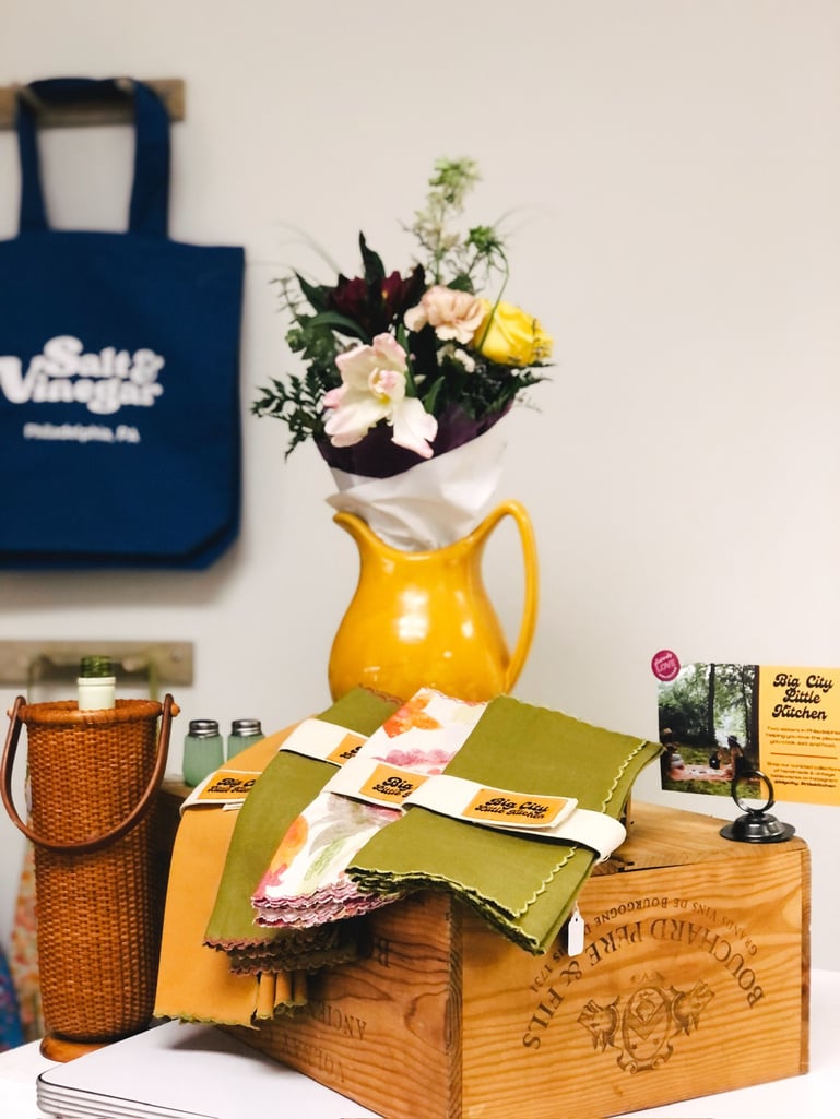 a table with a vase of flowers and clothe napkins on it