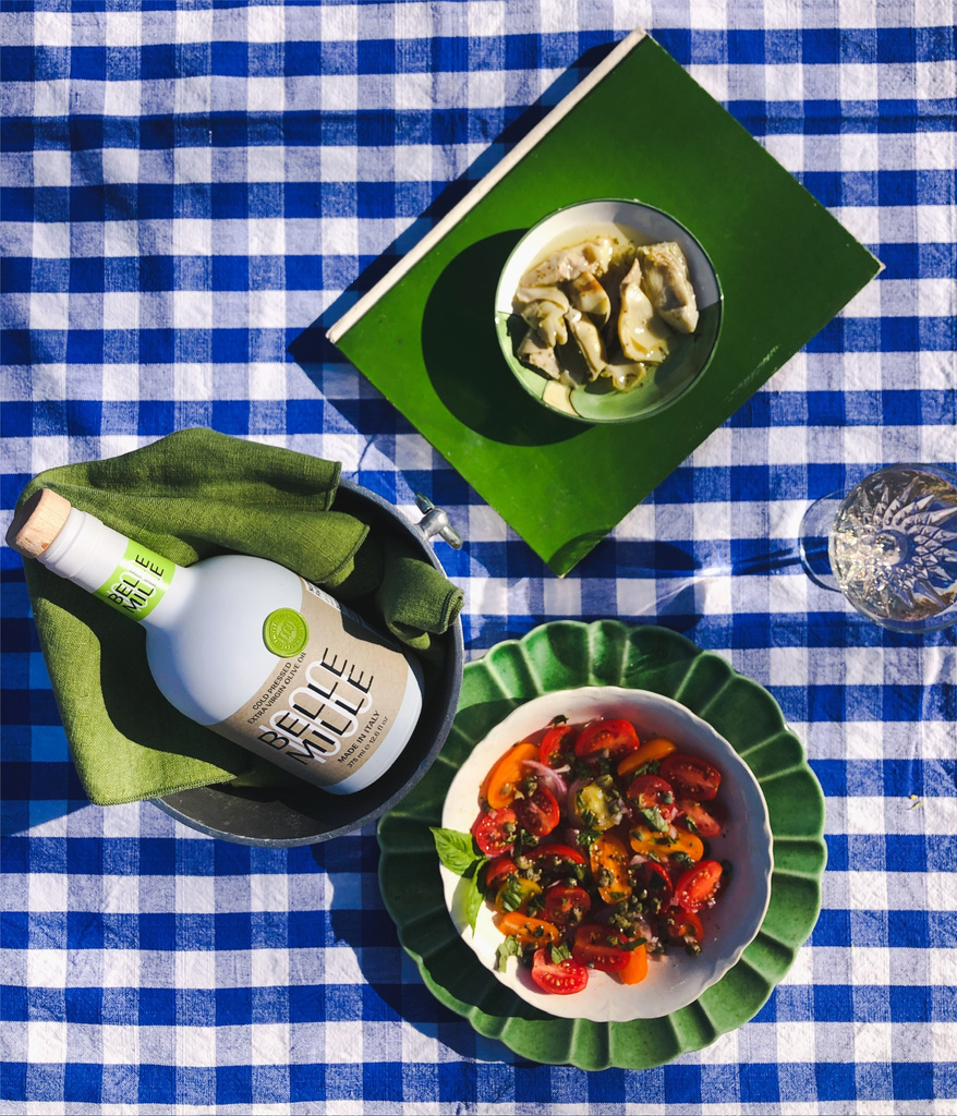 a bottle of wine and a bowl of food on a blue and white checkered tablecloth