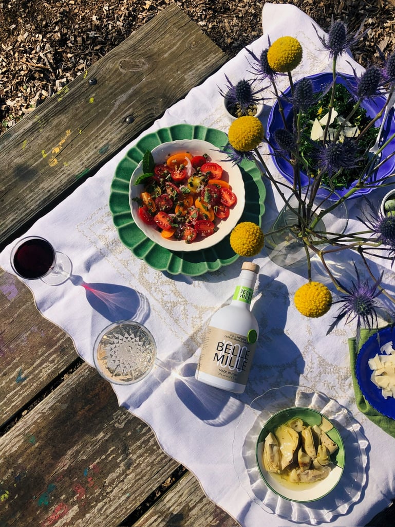 the table is made of wood and there are plates of salads and pastas.